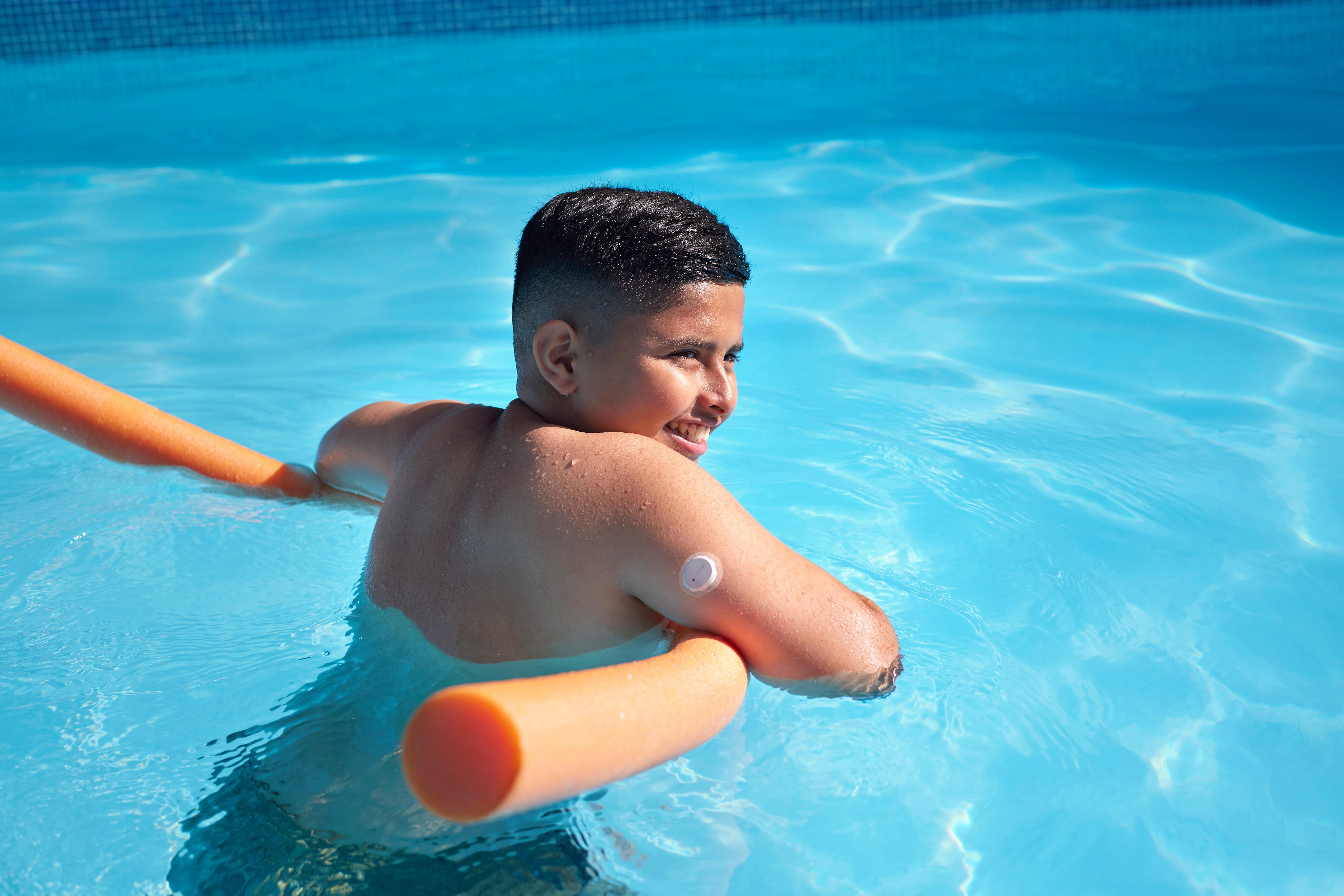 Sensor being worn on the back of the arm of a child swimming